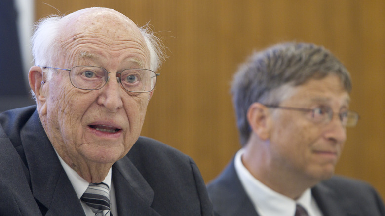 Bill Gates and William Gates Sr. speaking at a conference