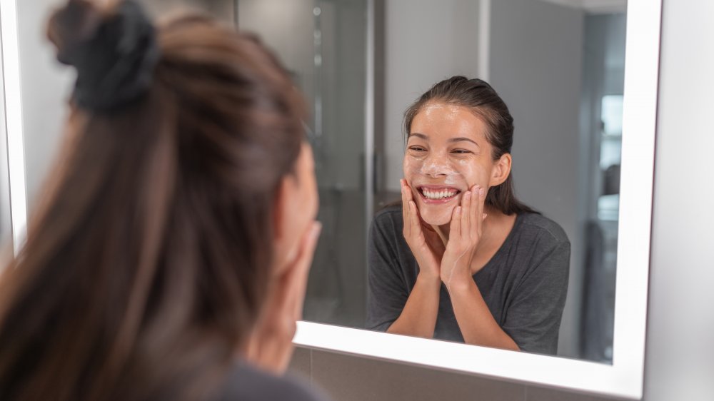 Woman exfoliating in the mirror