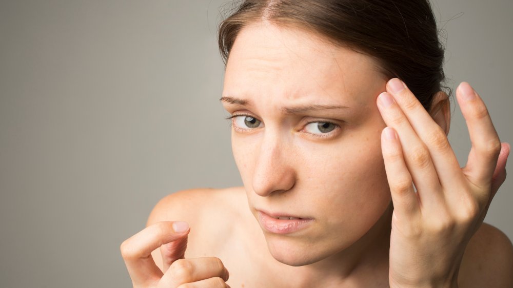 woman looking at blackheads