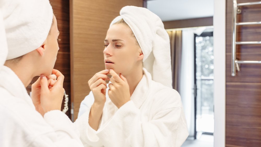 Woman in front of mirror looking at blackheads