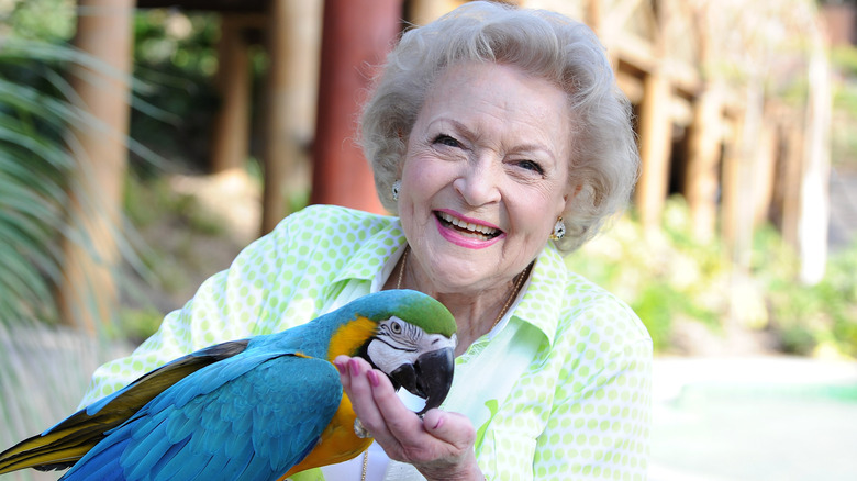 Betty White holding blue macaw