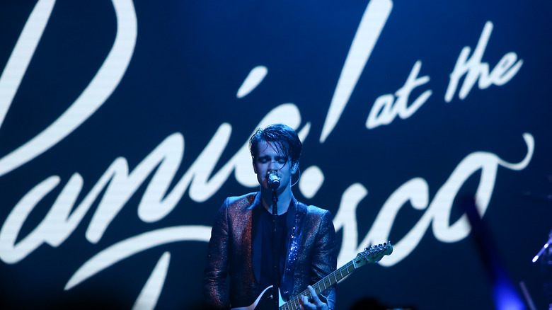 Brendon Urie playing guitar and singing on stage 