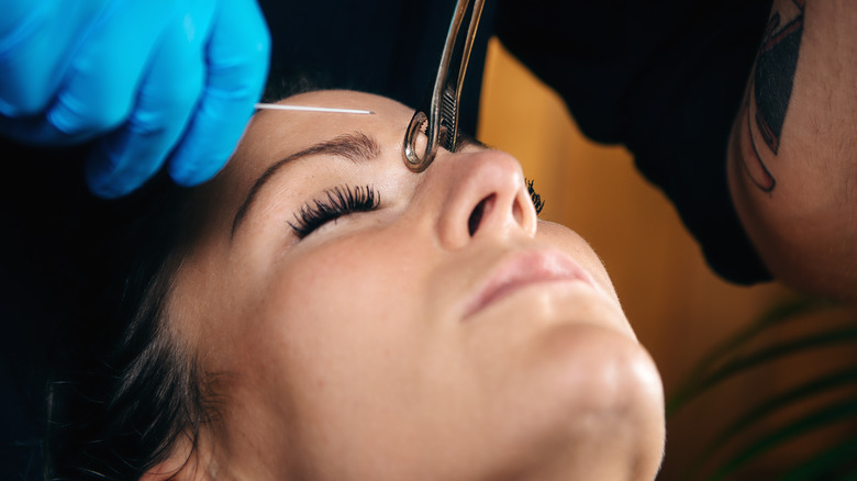 Woman getting bridge piercing