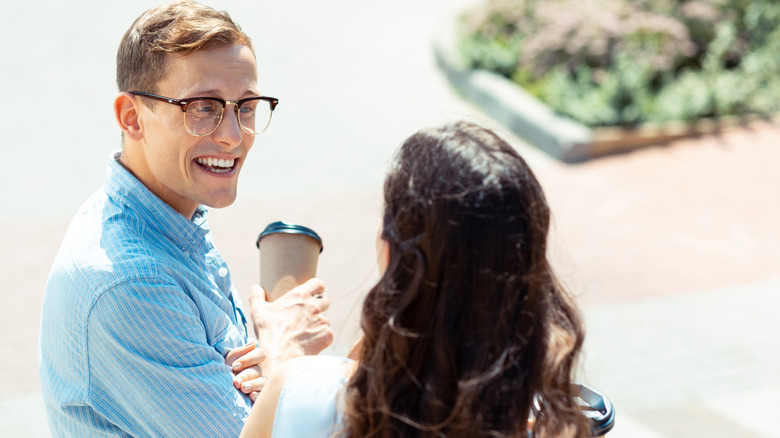 Blue-eyed man talking to a brunette