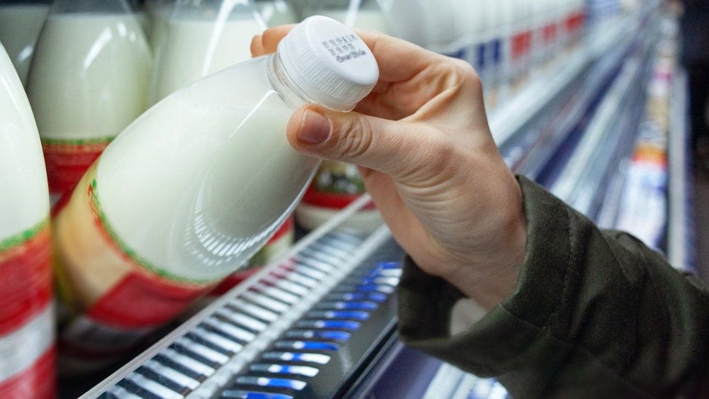 Woman buying milk in supermarket