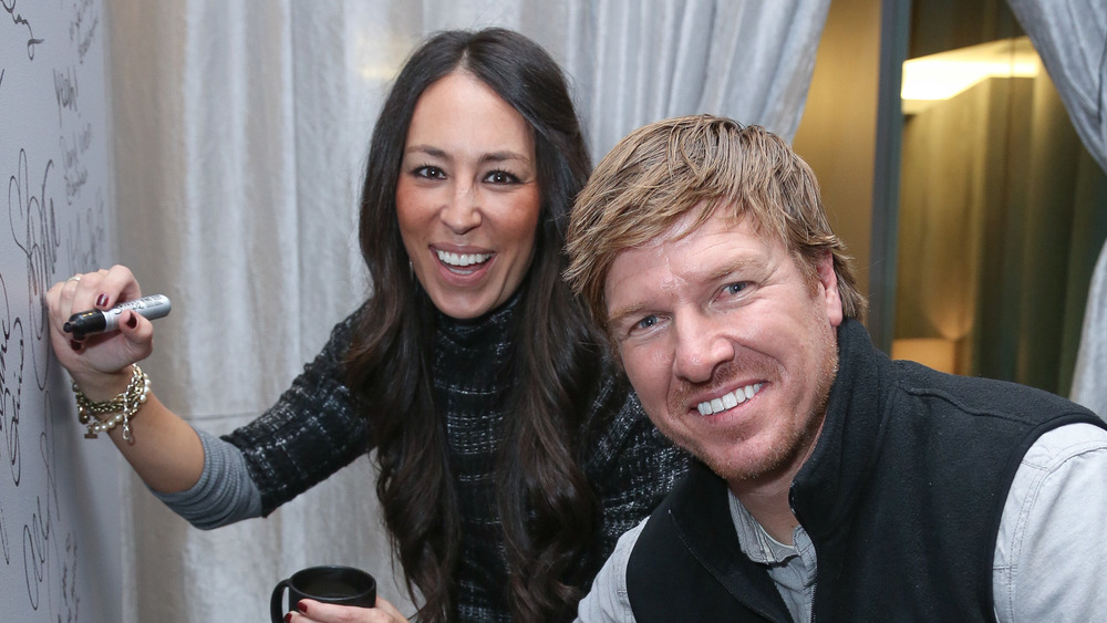 Joanna and Chip Gaines signing a wall