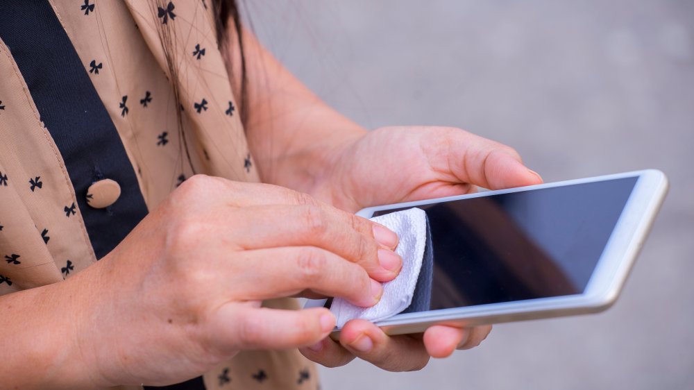 Cleaning a phone with a disinfectant wipe