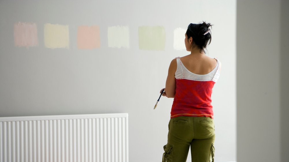 woman looking at different colored paint samples on the wall