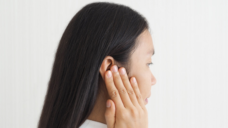 woman covering ear