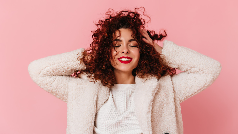 A woman touching her curly hair