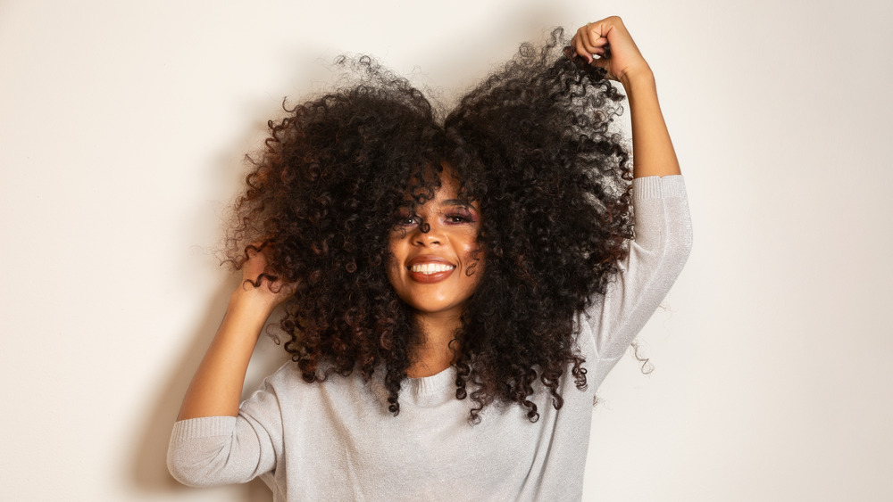 A woman teasing out her curly hair