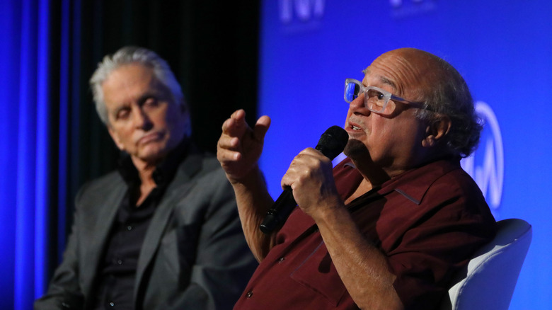 Michael Douglas looks on thoughtfully as his friend Danny DeVito speaks