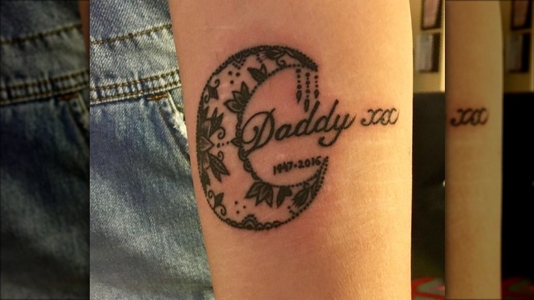 Tattoo of a crescent moon with the word "Daddy" inside