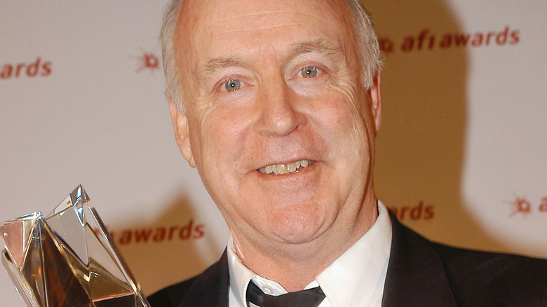 John Clarke holding award