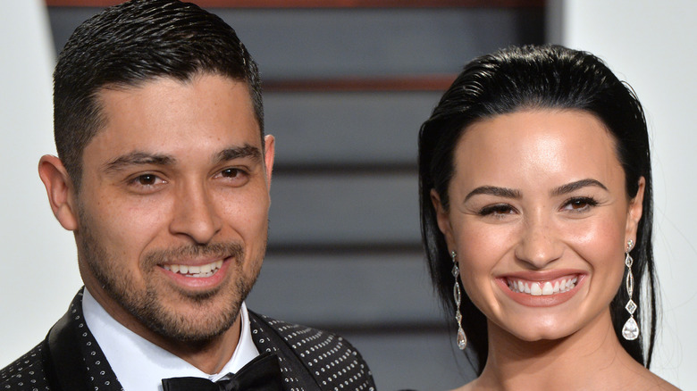 Wilmer Valderrama and Demi Lovato smiling together at an event