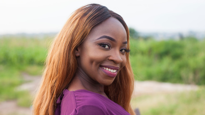 Woman with dimples side-smiling