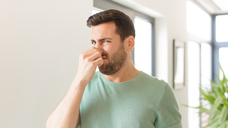 man holding nose