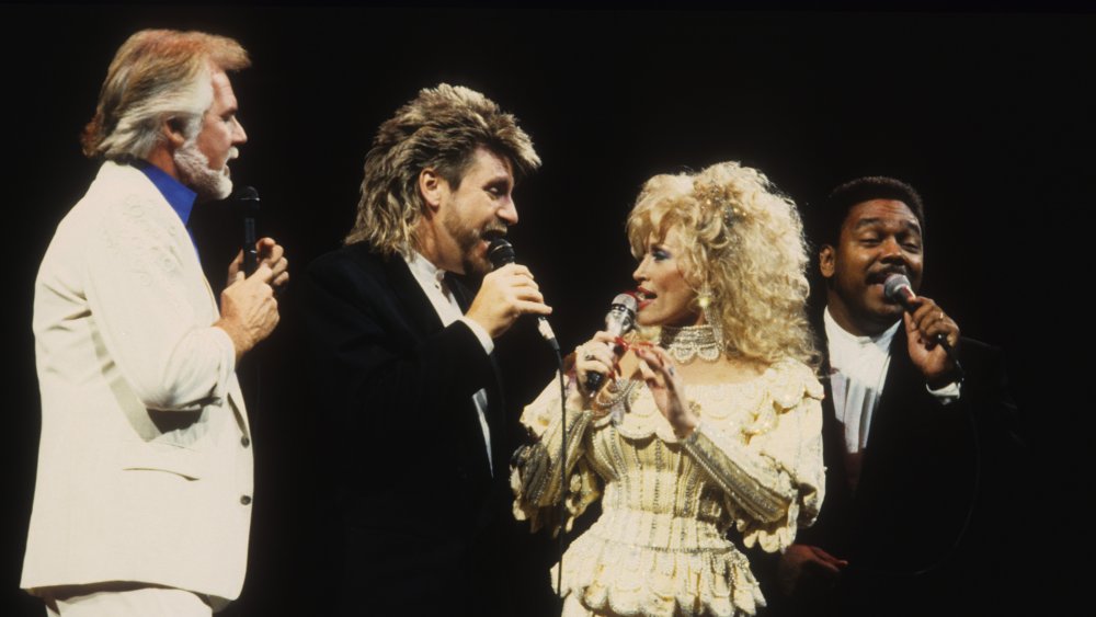 Kenny Rogers, Dolly Parton, and members of her band singing on stage