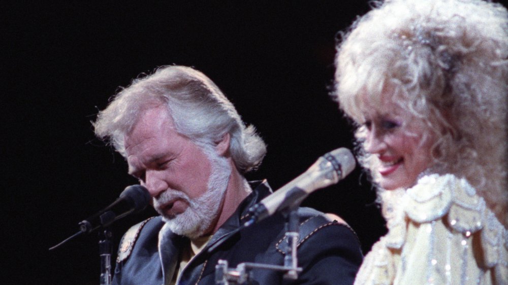 Kenny Rogers and Dolly Parton singing into mics