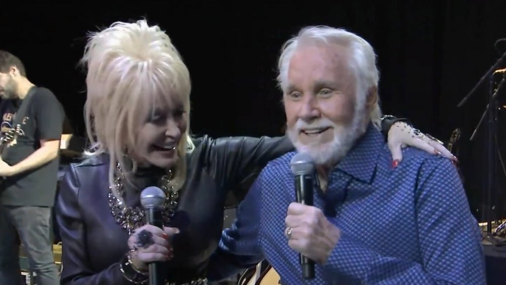 Dolly Parton and Kenny Rogers with their arms on each other's shoulders