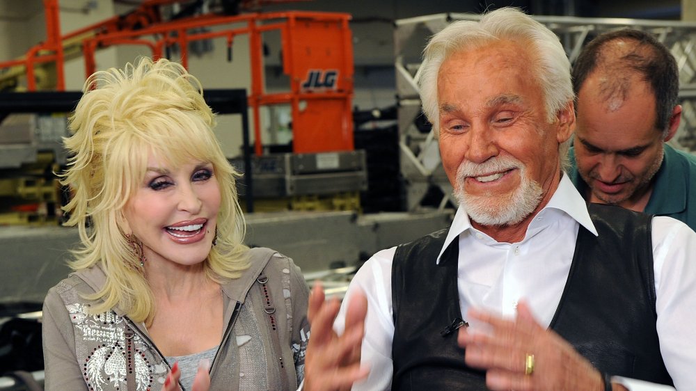 Dolly Parton  and Kenny Rogers smiling, having a discussion