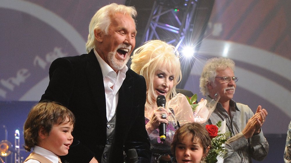 Kenny Rogers and Dolly Parton performing on stage with Rogers' sons