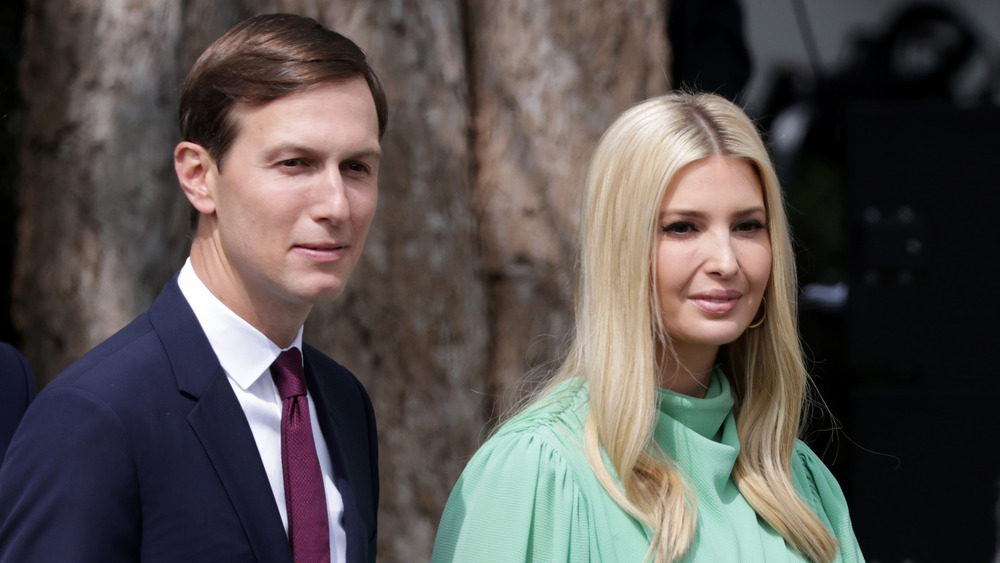 Jared Kushner in purple tie and Ivanka Trump with hair down in mint top smiling