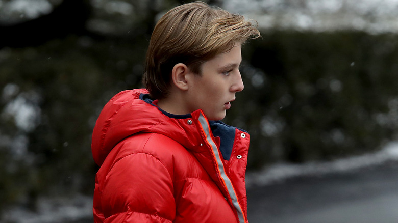 Barron Trump wearing a red coat