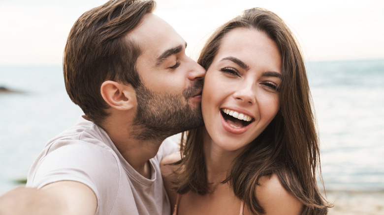 Couple smiling and man kissing woman