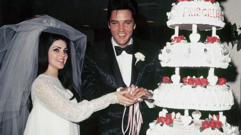 Elvis and Priscilla Presley cutting wedding cake 