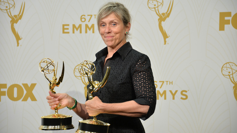 Frances McDormand holding two Emmys