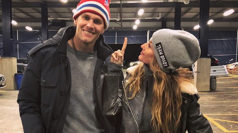 Gisele Bündchen wearing "Team Brady" hat beside Tom Brady