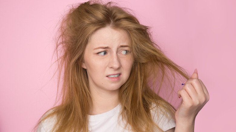 Woman looking worriedly at hair