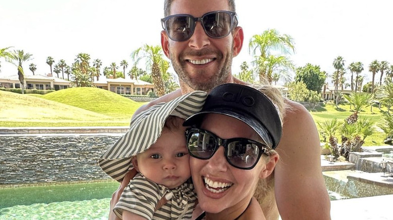 Tarek El Moussa and Heather Rae Young smiling with their son Tristan