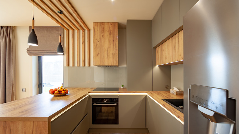 Kitchen with neutral colors and wood panel accents with wooden countertop