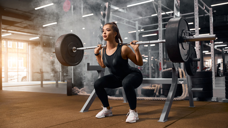 Fit woman squatting in the gym