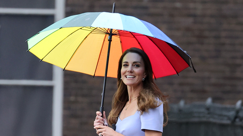 Kate Middleton smiling with umbrella