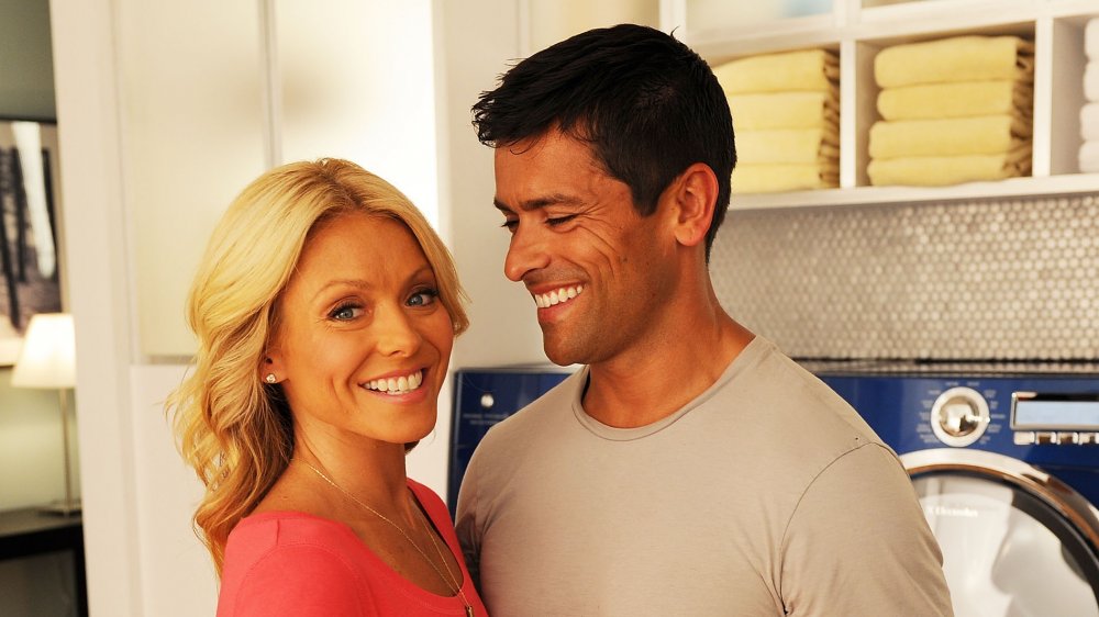 Kelly Ripa and Mark Consuelos in front of laundry machines