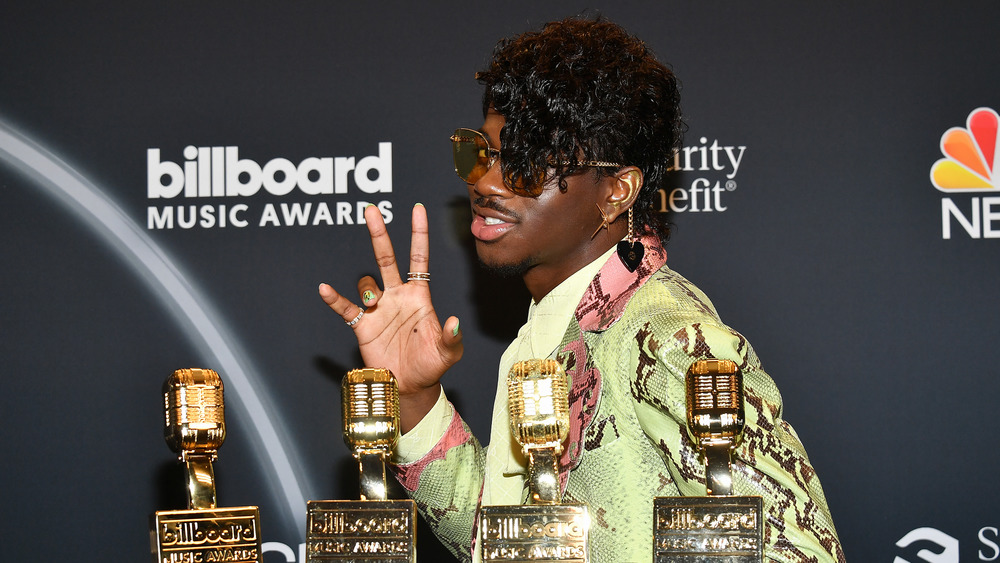 Lil Nas X posing with awards