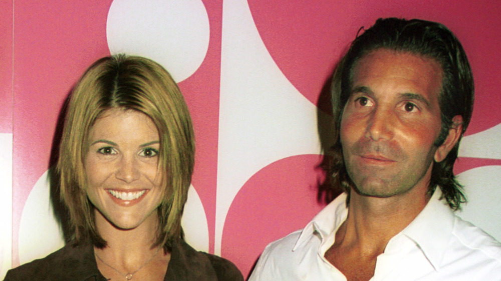 Lori Loughlin and Mossimo Giannulli in front of a pink and white wall