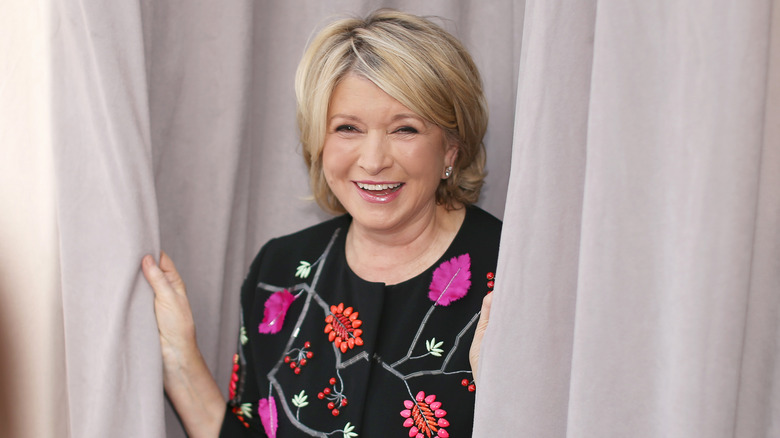 Martha Stewart peeks out behind some curtains