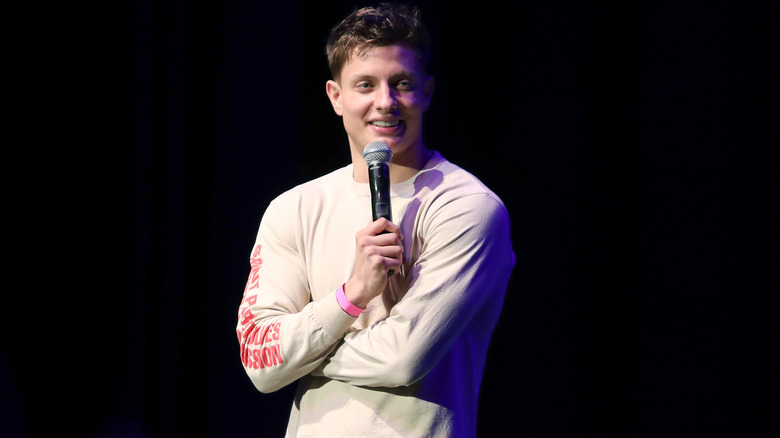 Matt Rife folding his arms onstage and holding mic