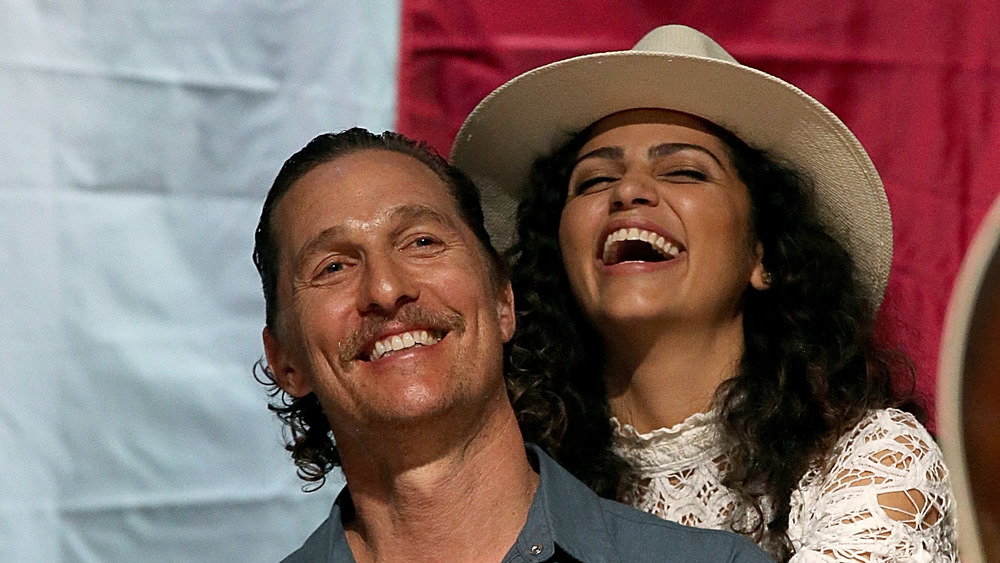 Camila Alves hugging Matthew McConaughey from behind