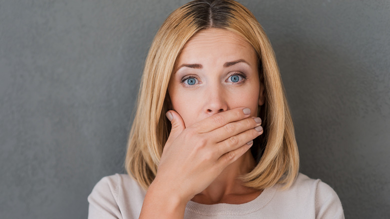 Woman covering mouth