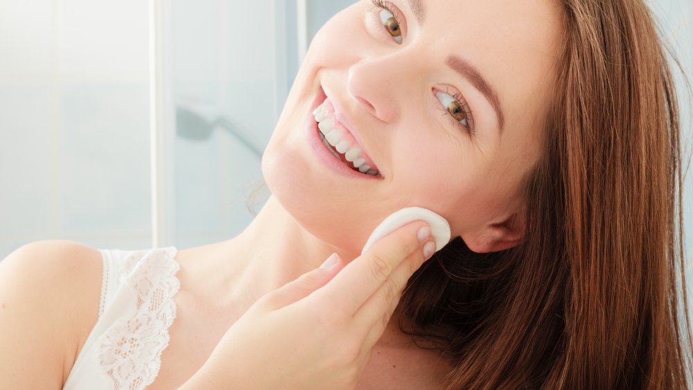 woman cleaning her face