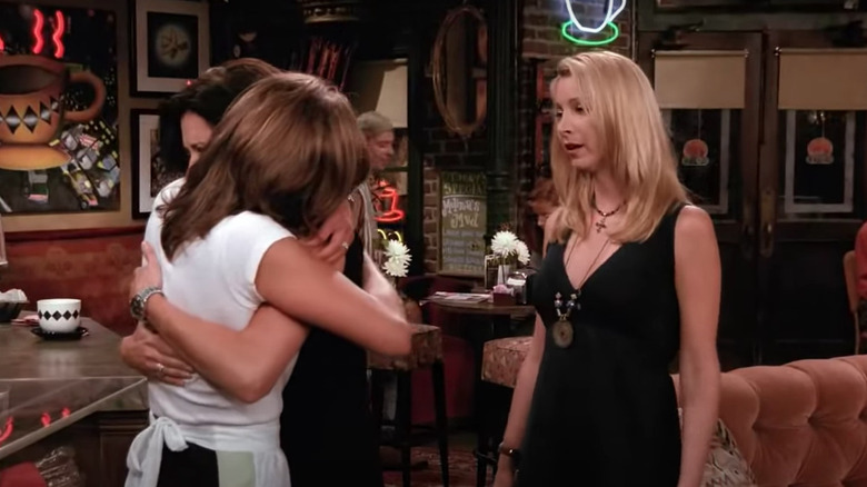 Monica and Rachel hug in front of Phoebe in "Friends"
