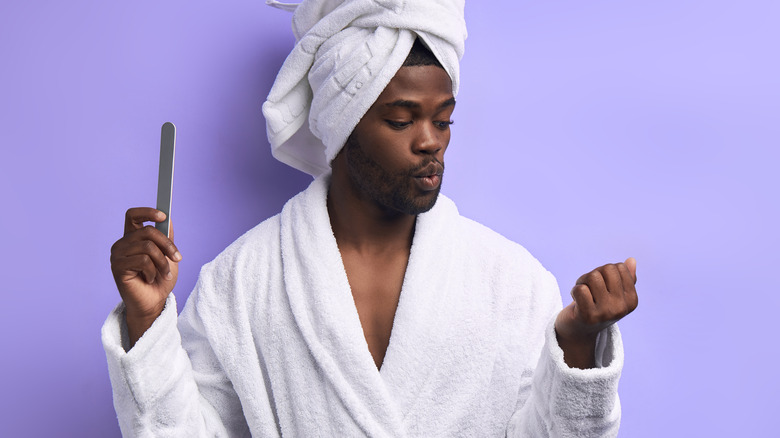 Man in bathrobe ready to file his nails