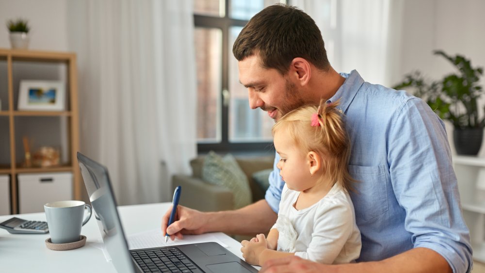 dad taking care of child and working from home