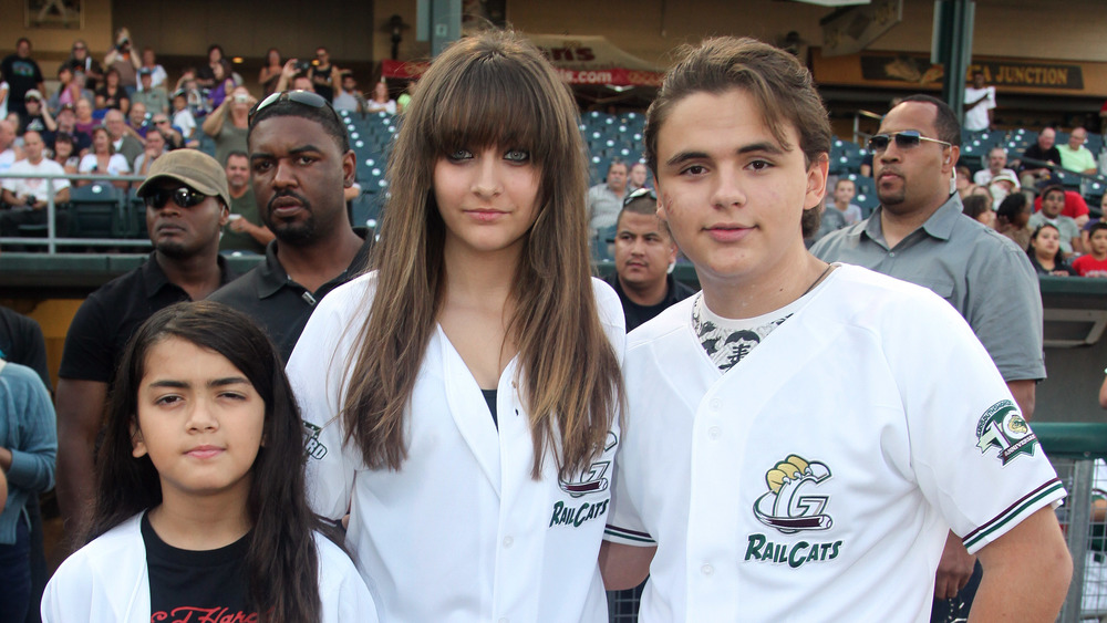 Paris, Blanket, and Prince Jackson at a sporting event