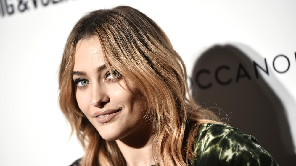 Paris Jackson smiling, wearing green